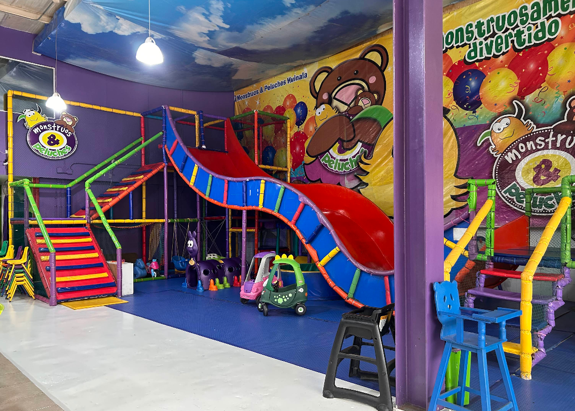 Área de juegos con tobogán y estructuras infantiles